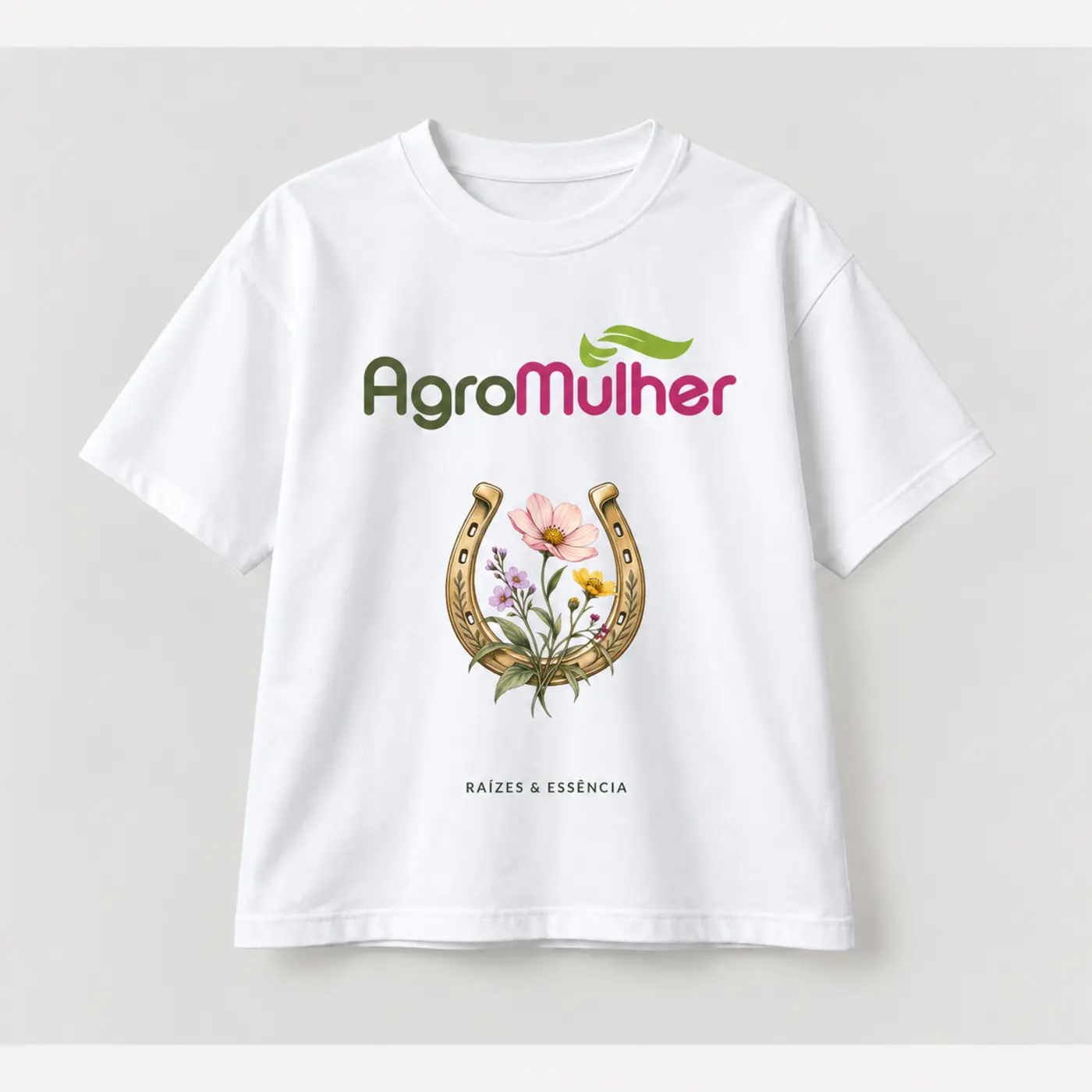 T-shirt branca AgroMulher Raízes e Essência com ferradura dourada e flores do campo